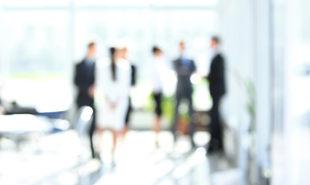 Blurred,Image,Of,Business,People,Standing,In,Office.business,Background