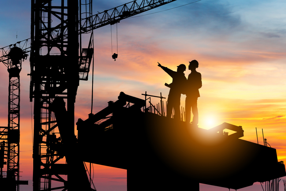 Silhouette,Of,Engineer,And,Worker,Checking,Project,At,Building,Site