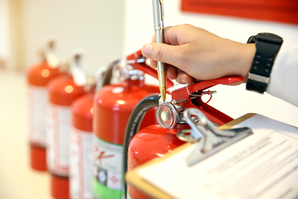 Fireman,Are,Checking,And,Inspection,Red,Tank,Of,Fire,Extinguisher.concepts