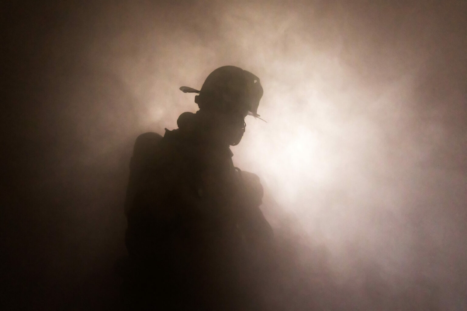 Firefighter,In,Full,Turnouts,Silhouetted,In,Smoke