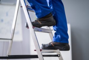 Low,Section,View,Of,A,Handyman's,Foot,Climbing,Ladder
