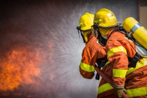 2,Firefighters,Spraying,High,Pressure,Water,To,Fire,With,Copy